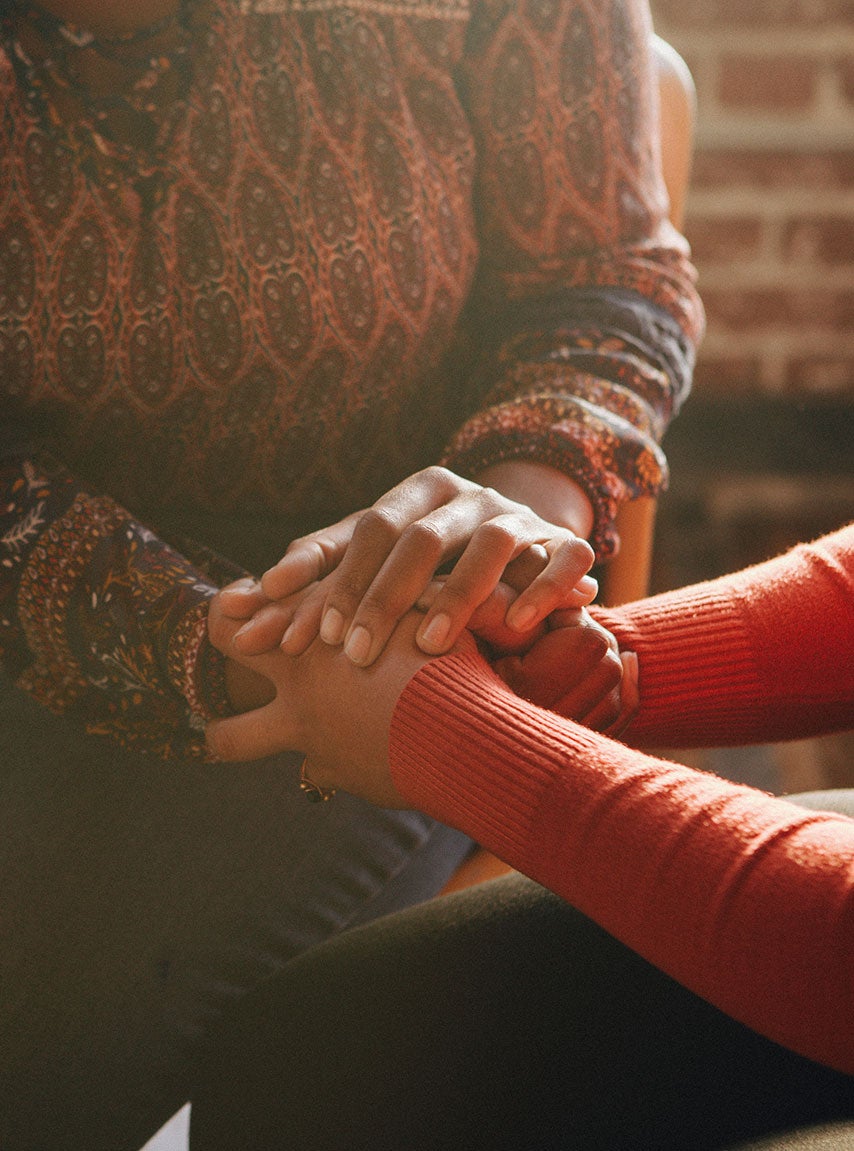 person comforting another by holding hands