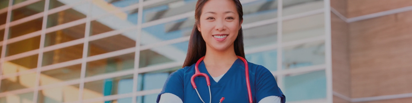 Smiling Doctor Standing in Front of Hospital