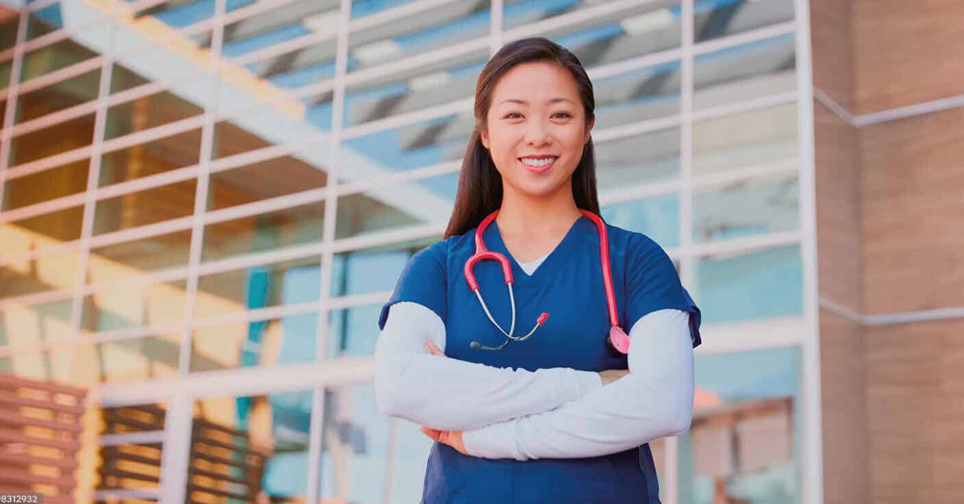 Smiling Doctor Standing in Front of Hospital