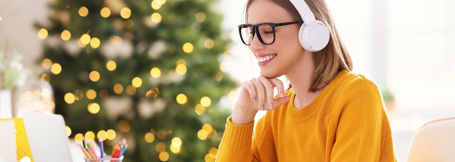 Person watching online CME on laptop with Christmas tree in background