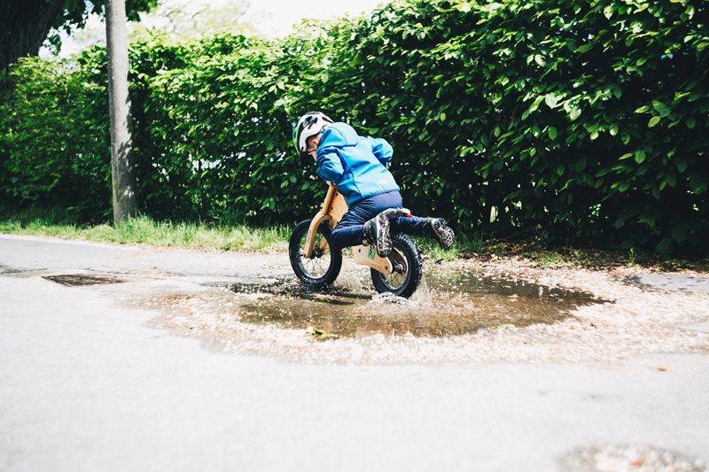 kid cycling in mud