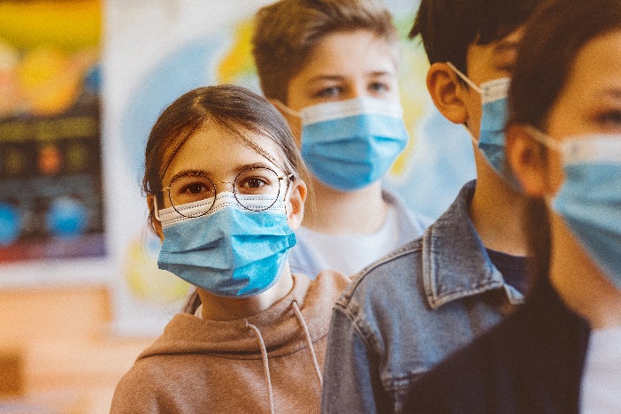 Elementary students in line with face coverings