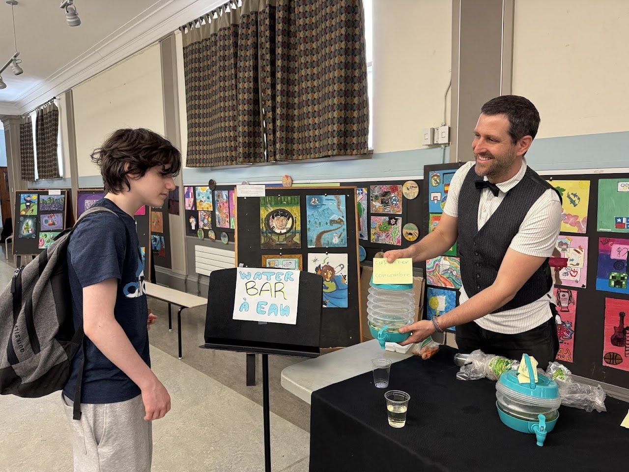A FACE student visiting the school nurse’s water bar, surrounded by student artwork