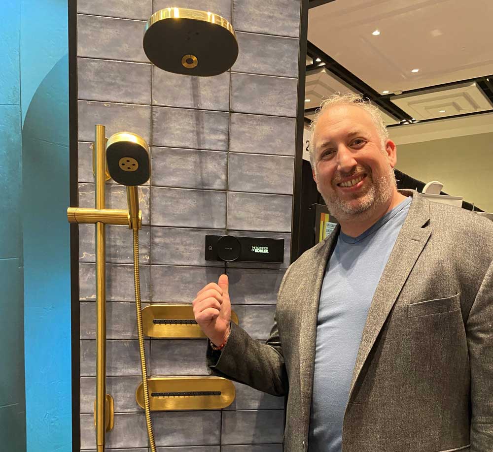 Ben Levine showing a new Kohler shower faucet at a trade show on November 1. Photo courtesy of Levine Bros.