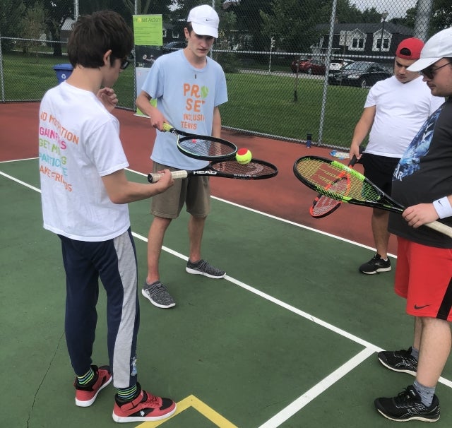 Photo: Toren Pleasence, 17, on task instructing his students in a tennis lesson at Proset Autism. Photo courtesy of Lara Pleasence