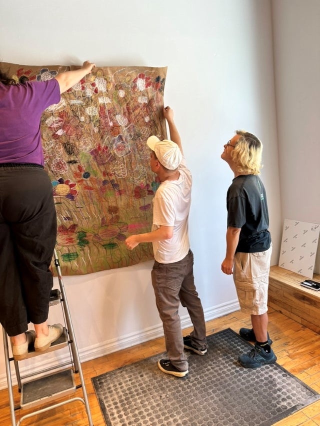 Art curators Matthew Brotherwood and Jorden Harris-Bignel installing the year-end show with Visual Arts Centre executive director Amber Berson.