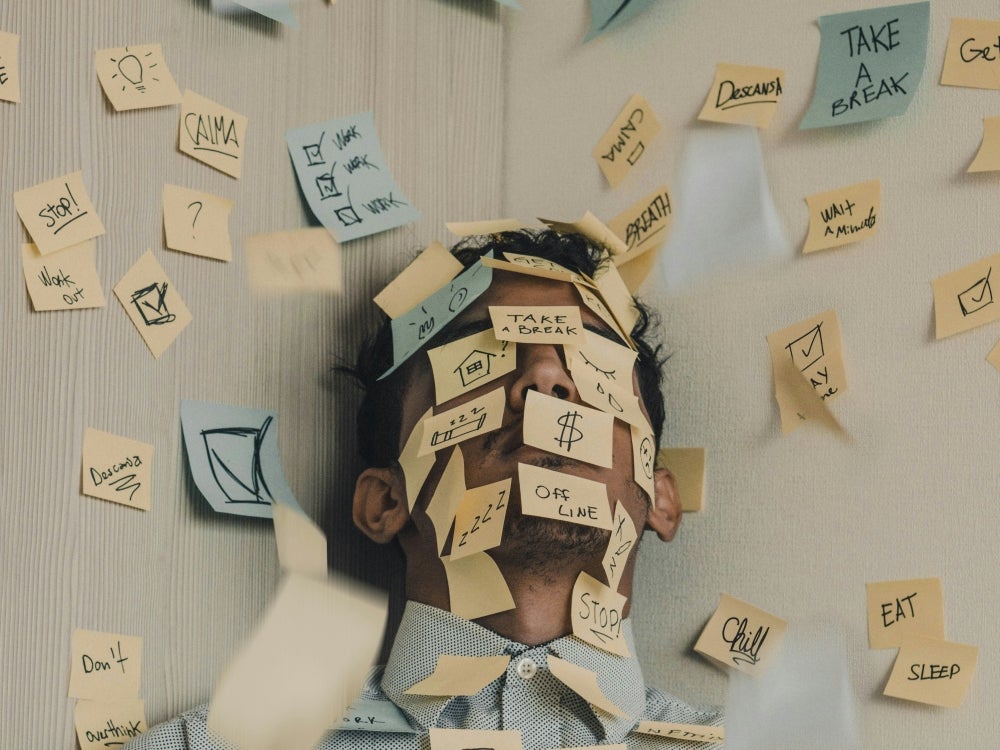 A photo of a person whose face we can't see, and it's covered with post-it notes with little messages on them.