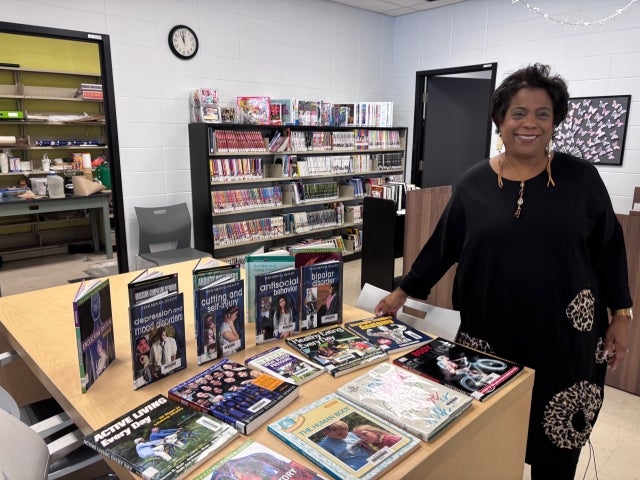 Marjorie Michel is seen here looking toward the camera while in the John F. Kennedy High School library