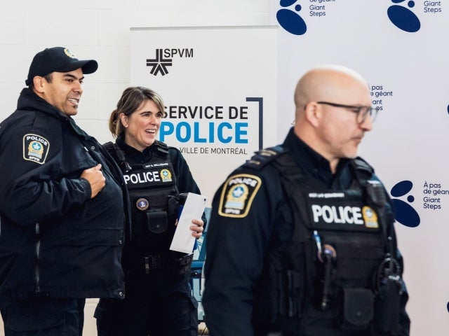  Three police officers looking off to the side at apress conference of AutSecours