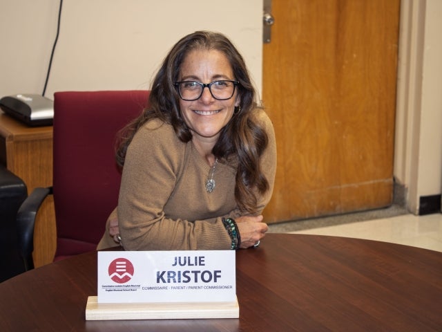 Julie Kristof sitting with a name plate in front of her at a council meeting 