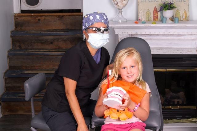 Using a plastic model, mobile dental hygienist Joy Maderazo teaches Emma St-Laurent the ideal way to brush her teeth, while comfortable at home. Photo courtesy of Joy Maderaz