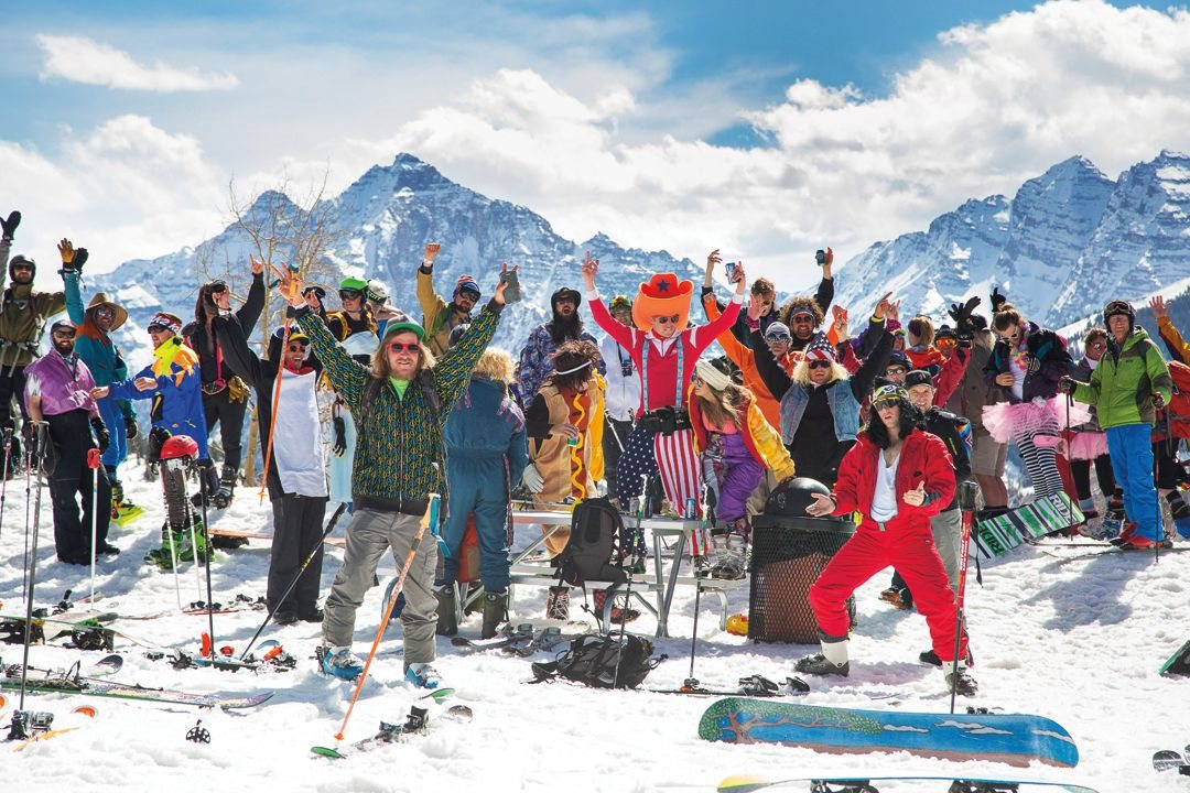 people partying in ski gear in front of mountains