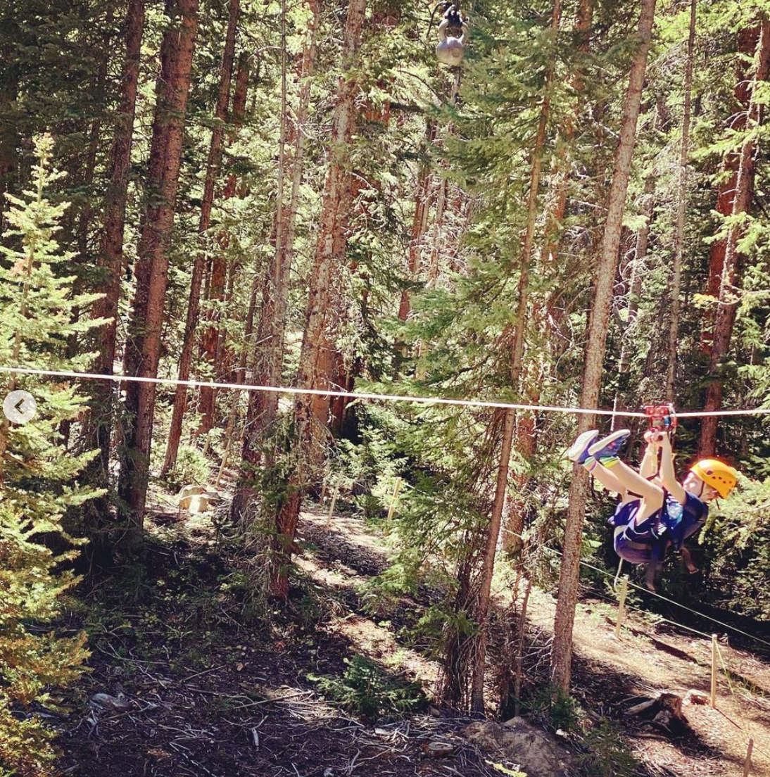 kid hanging from rope in mountains