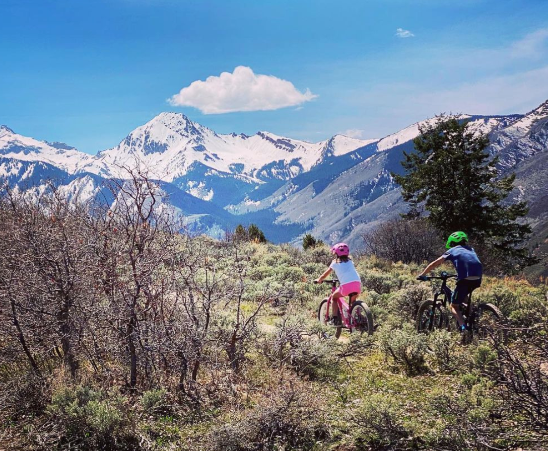 kids biking with aspen mountain in background