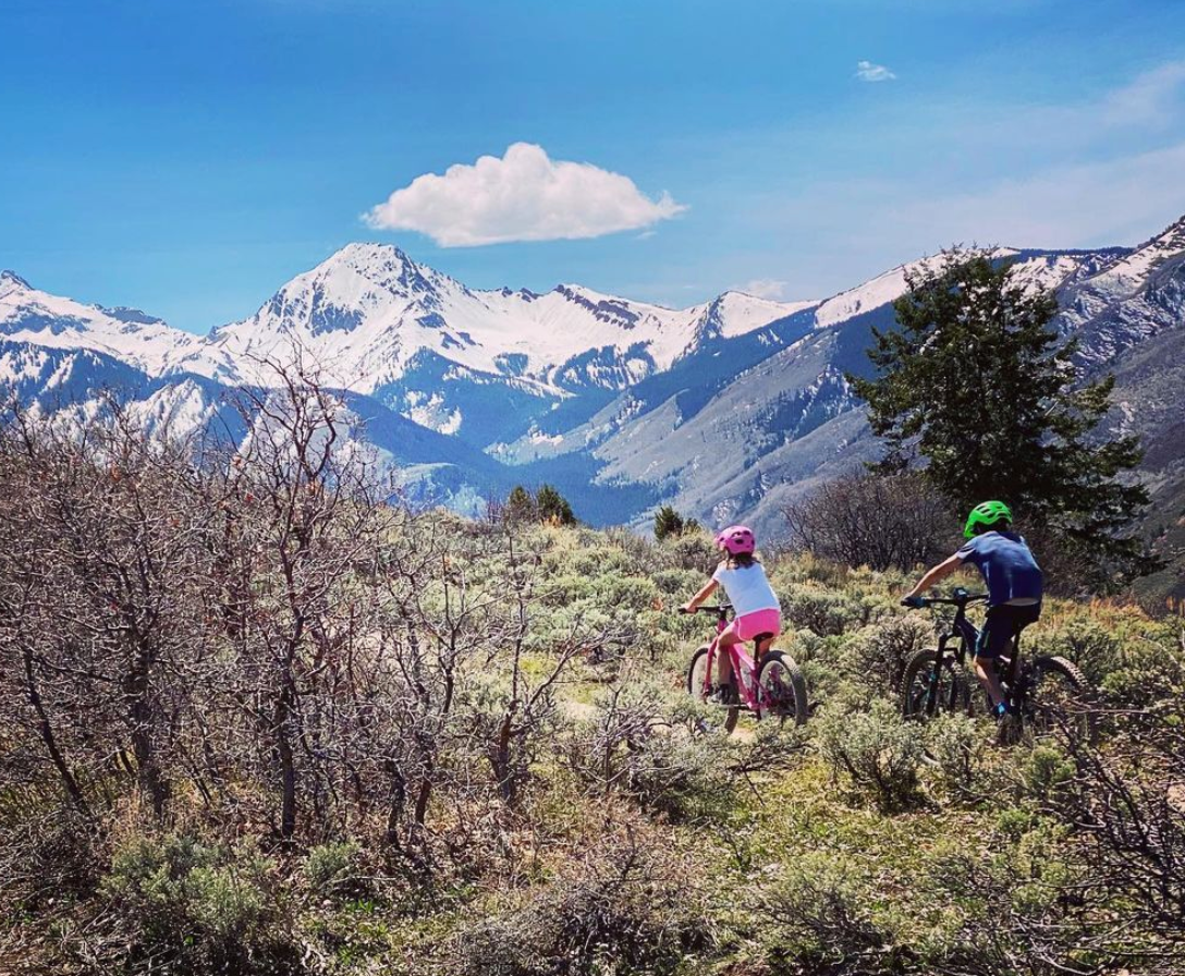 kids biking with aspen mountain in background