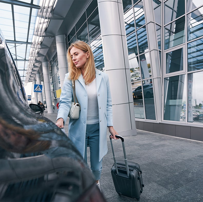 Persona viajando con maleta en aeropuerto, representando el Seguro de Viaje Scotia Travel con cobertura internacional, asistencia m&eacute;dica y protecci&oacute;n de equipaje