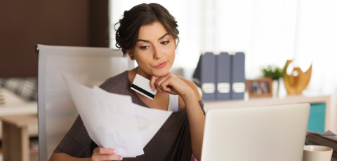 mujer pensativa revisando sus estados de cuentas bancarias