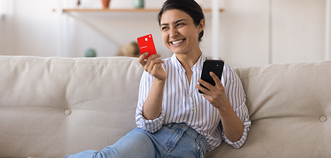 chica joven con tarjeta de crédito en la mano, sonriendo