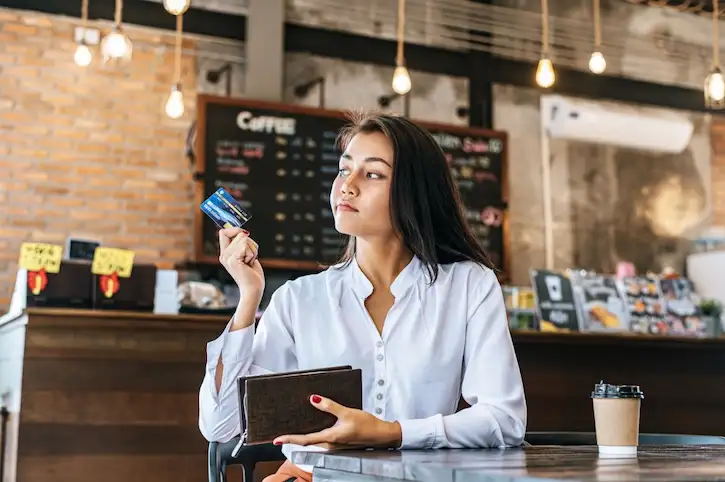 Mujer toma control de sus gastos variables con su tarjeta de ahorros