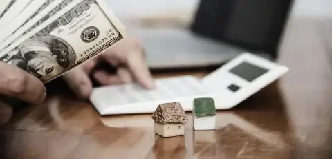 Persona caucasica sosteniendo billetes pensando en como hacer un plan de ahorro mensual