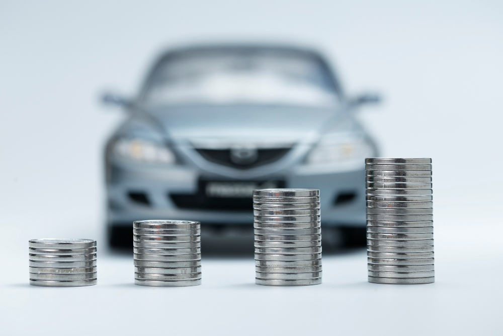 Monedas apiladas frente a un auto