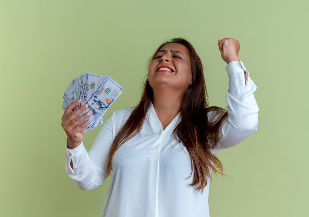 mujer sosteniendo billetes de prestamo con un gesto de logro