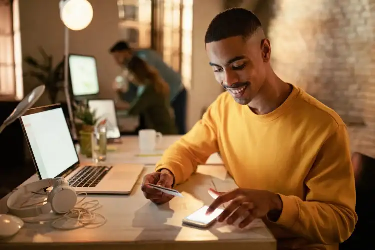 Joven revisando sus beneficios de disponer de efectivo con tarjeta de crédito