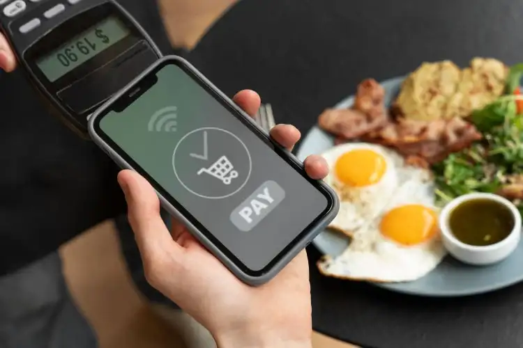 Persona pagando en restaurante con Apple Pay