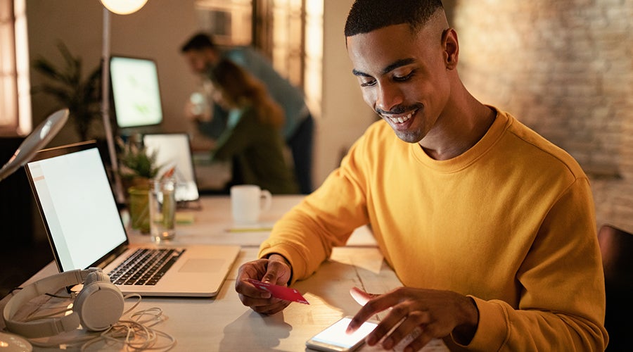 Joven revisando sus beneficios de disponer de efectivo con tarjeta de crédito