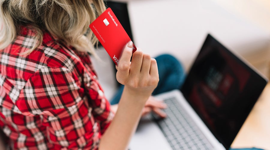 joven explorando internet en busca de compras online con su tarjeta de d&eacute;bito