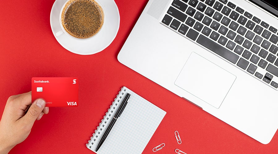 vista cenital de una mano con una tarjeta de cr&eacute;dito y otros accesorios