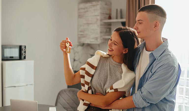 Pareja feliz sosteniendo las llaves de su nueva vivienda