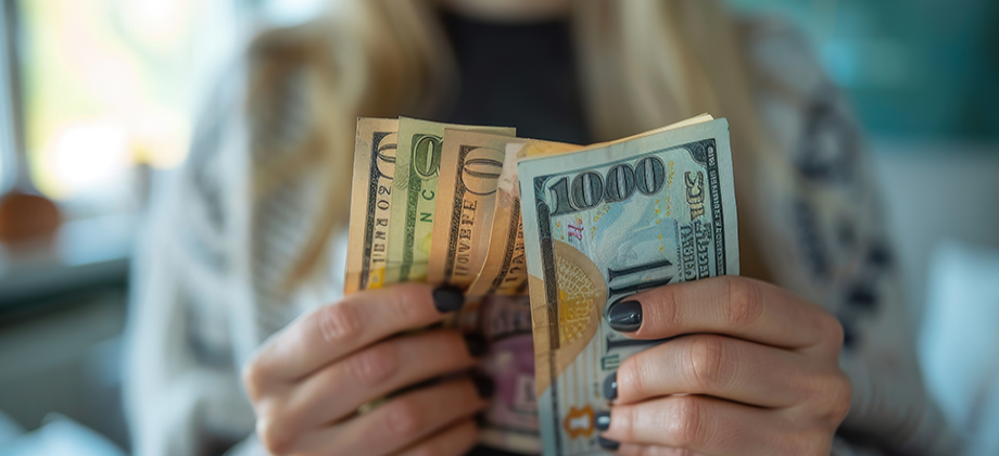 Persona sostiene billetes de d&oacute;lares en la mano