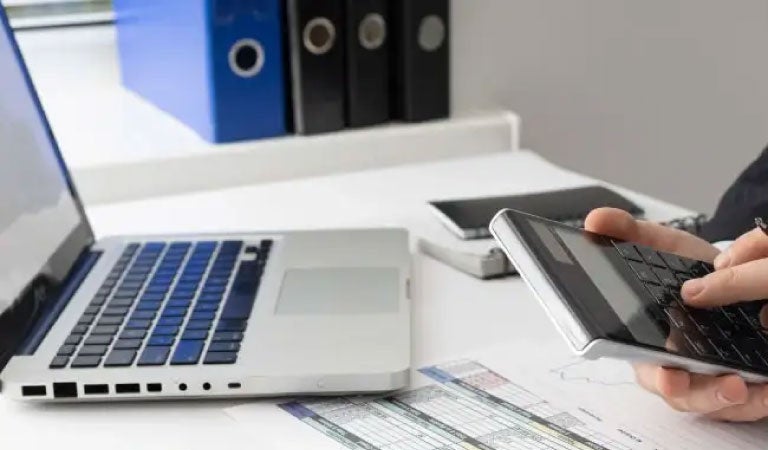 persona haciendo un c&aacute;lculo de apalancamiento financiero