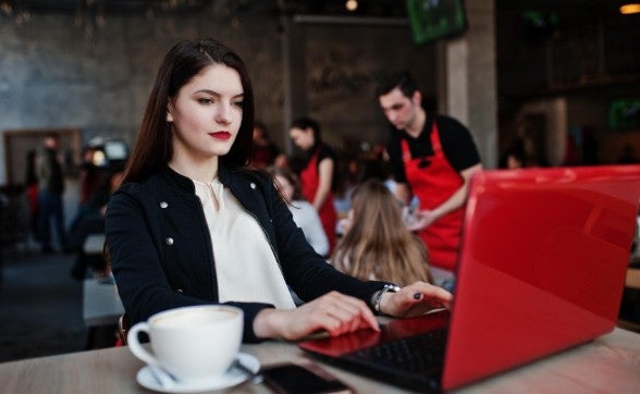 chica joven trabajando en su laptop roja