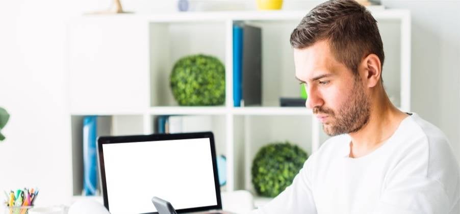 j&oacute;ven empresario calculando las utilidades de su empresa mediante la hoja de c&aacute;lculo