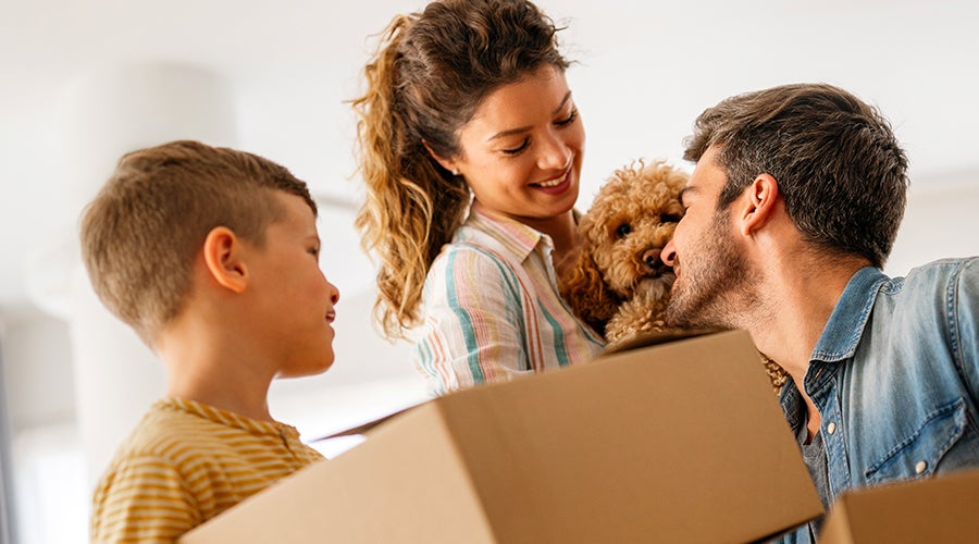 Persona sosteniendo una maqueta de una casa y una alcancía, representando el ahorro y el financiamiento para comprar una vivienda