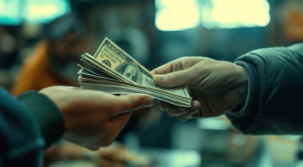 Hombre realiza cambio de dólares a soles en un banco