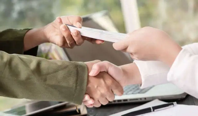 personas firmando un pr&eacute;stamo por apalancamiento financiero