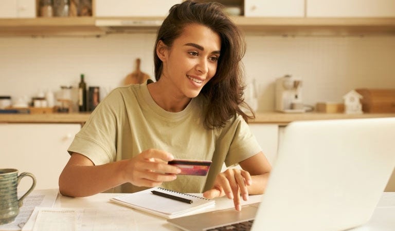 mujer joven utilizando su tarjeta de d&eacute;bito scotiabank aprovechando las tasas de inter&eacute;s 2025