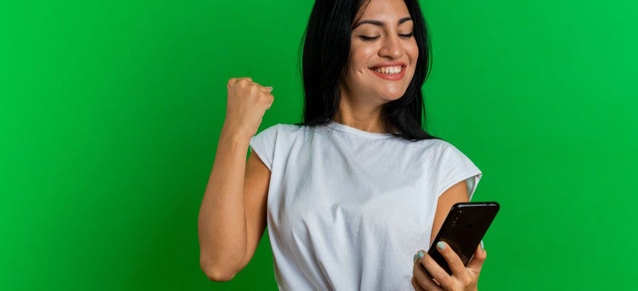 chica joven sonriendo viendo su teléfono