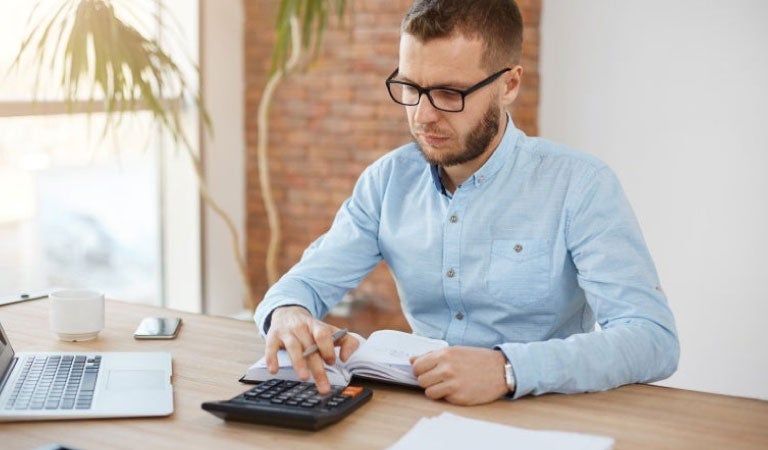 Hombre calculando las tasas de interes bancos
